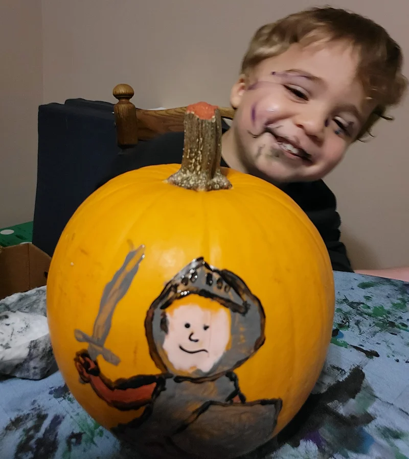 Z'kyan grinning with a pumpkin he painted as a knight